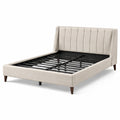 Letto matrimoniale in velluto beige con testiera imbottita e gambe in legno